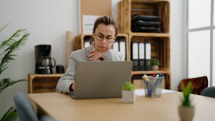 A practice manager working on a laptop at her desk