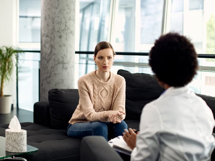 A young woman in a session with a therapist in a calm, light-filled office