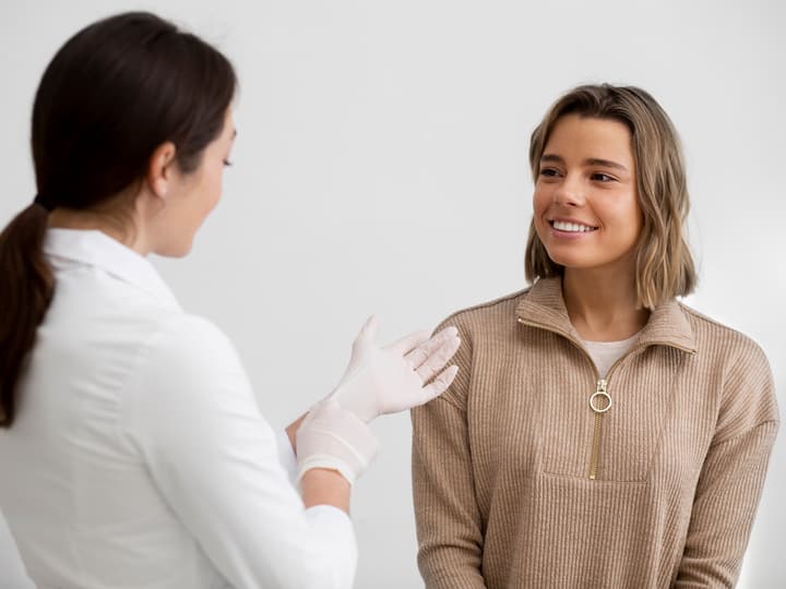 A dermatologist talking with a smiling patient