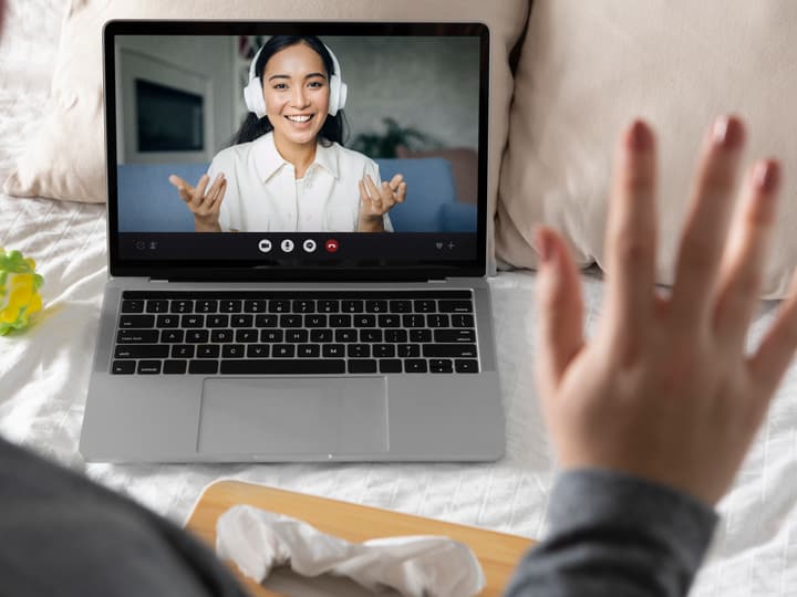 A telehealth therapy session on a laptop