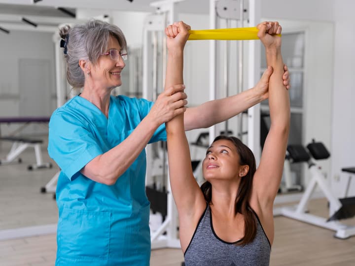 A physical therapist guiding a patient through a resistance band exercise