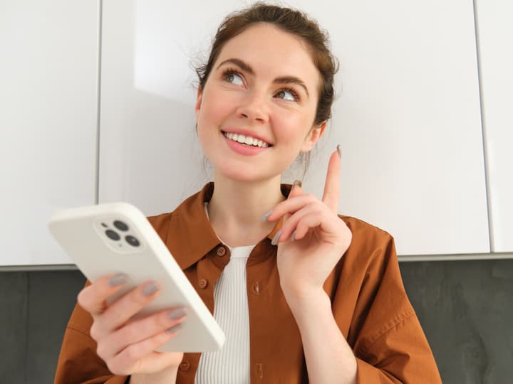 A woman thinking while asking a question on her phone