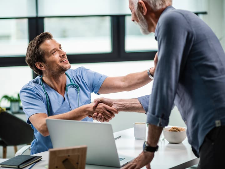 A clinician shaking hands with a returning patient